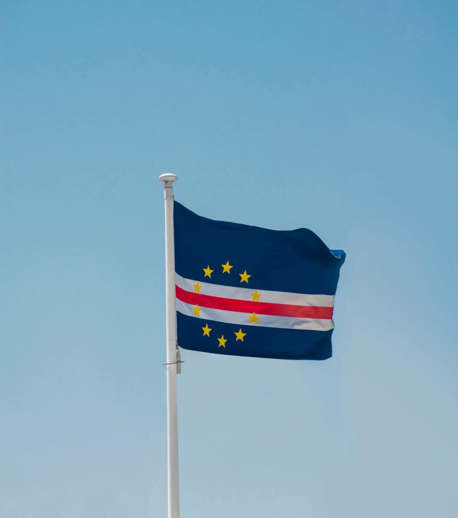 Bandeira de Cabo Verde içada num mastro contra um céu azul